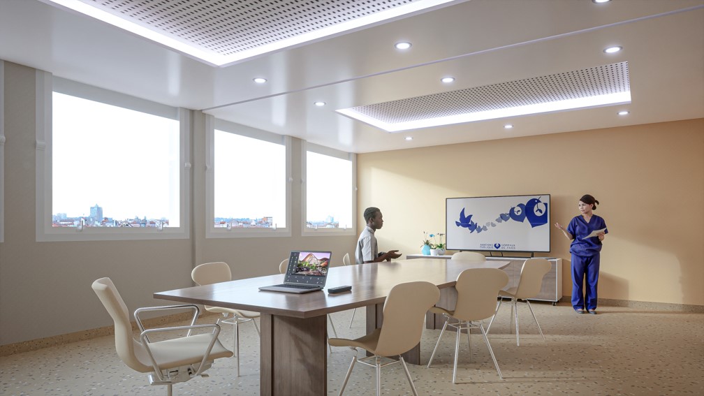 Salle de réunion éclairée au sein de l'Hôpital Necker conçue par A26 avec un personnel en discussion, illustrant l'engagement envers les innovations médicales et la formation continue