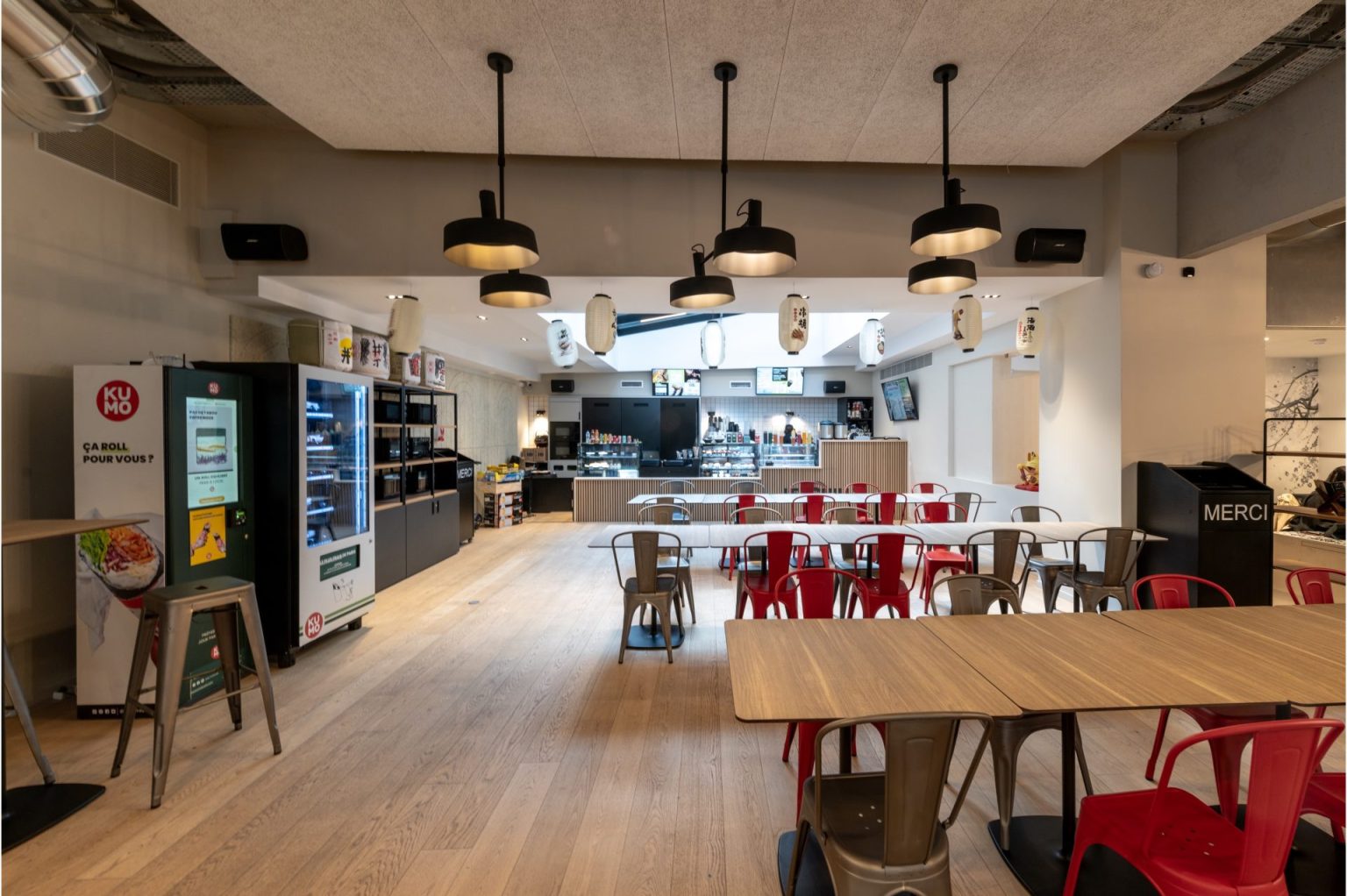 Principes d'éco-conception architecturale appliqués par A26 Architectures dans un espace cafétéria moderne, soulignant le bien-être des étudiants sur un campus innovant, avec un accent sur les matériaux durables et la lumière naturelle.