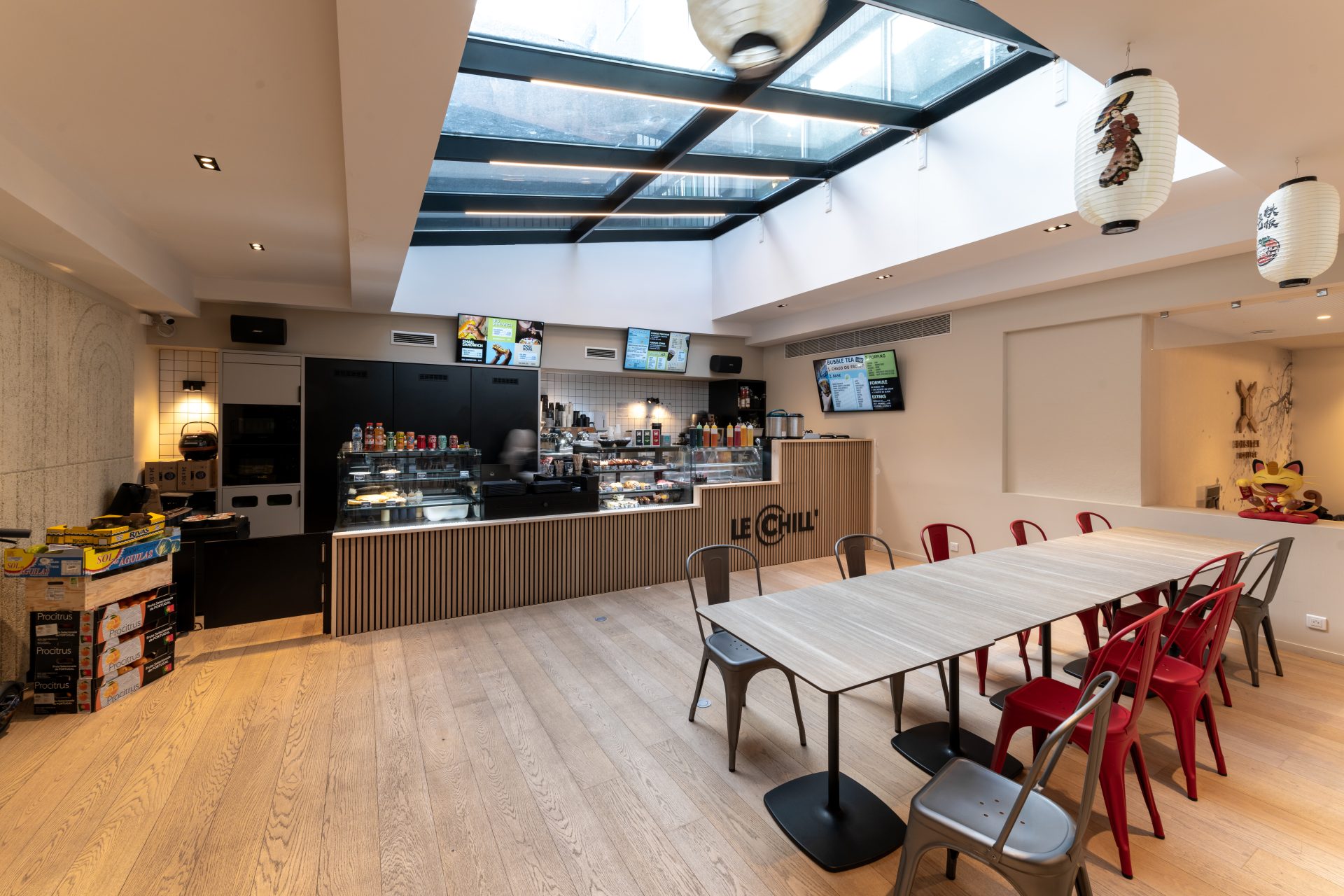 Cafétéria étudiante avec éclairage naturel et mobilier moderne, mettant en évidence la réversibilité de l'espace de bureau d'A26