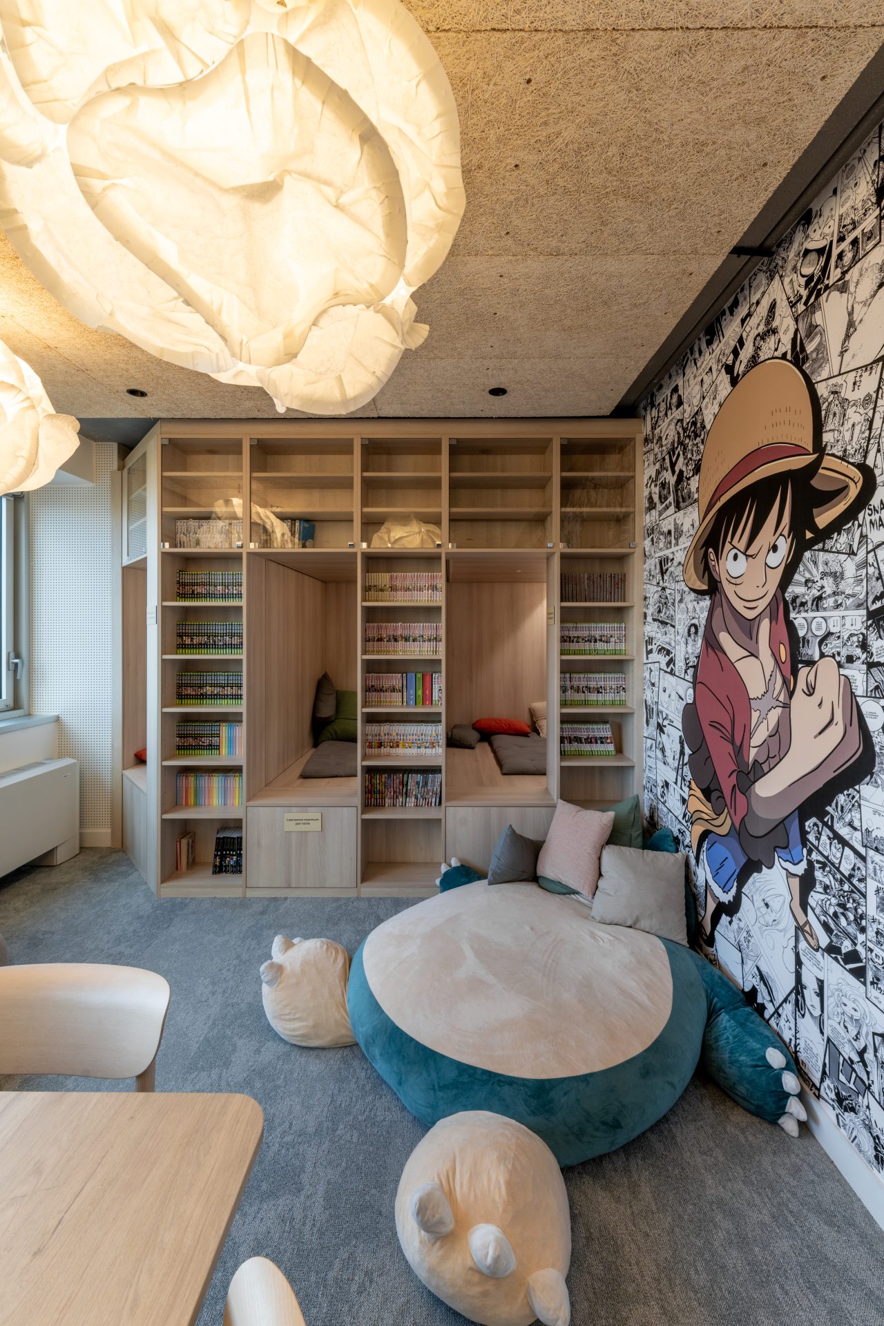 Coin détente dans un établissement éducatif avec des sièges confortables et des décorations murales, soulignant la flexibilité de la conception d'A26